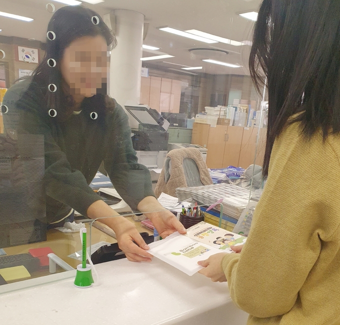 수원시 행정복지센터 담당자가 시민에게 아동학대 예방 홍보물을 건네고 있다. (사진=수원시 제공) 