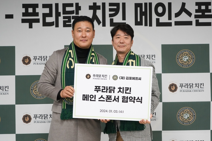 김포FC가 오븐-후라이드 전문치킨 브랜드 ‘푸라닭 치킨’과 2년간 메인 스폰서십을 체결, 두 대표가 기념사진을 찍고 있다. (사진=(재)김포FC제공)