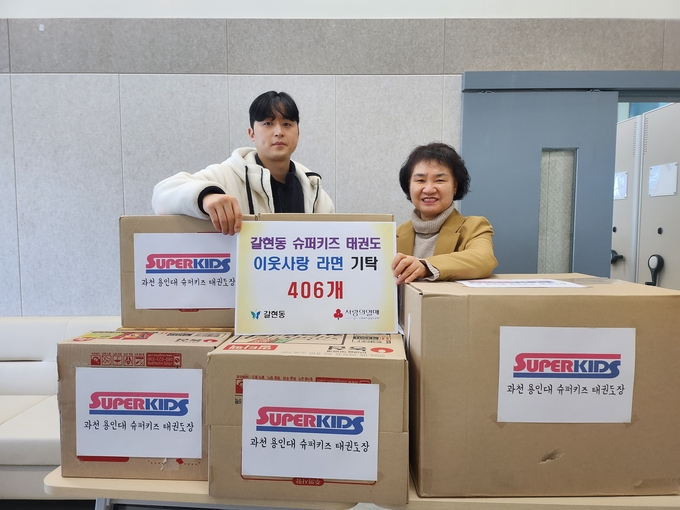 과천용인대 슈퍼키즈 태권도장이 ‘사랑의 라면 꾸러미’를 갈현동 행정복지센터에 전달하고 있다. (사진=과천시 제공)