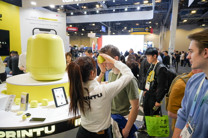 CES 2024 임프린투 부스에서 한 관람객이 임프린투 기기로 자신의 얼굴에 타투를 그려 넣고 있다. (사진=LG생활건강 제공)