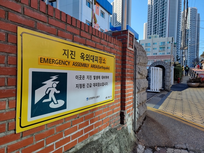 학교 입구에 설치된 ‘지진 옥외대피장소’ 안내판. ( 사진 = 김민지 기자 )