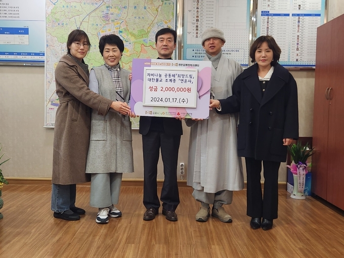 불교조계종 연운사 주지 스님이 두정호 양촌읍장에게 어려운 이웃에게 전해달라며 성금을 기탁 기념사진을 찍고 있다. (사진=양촌읍 제공)