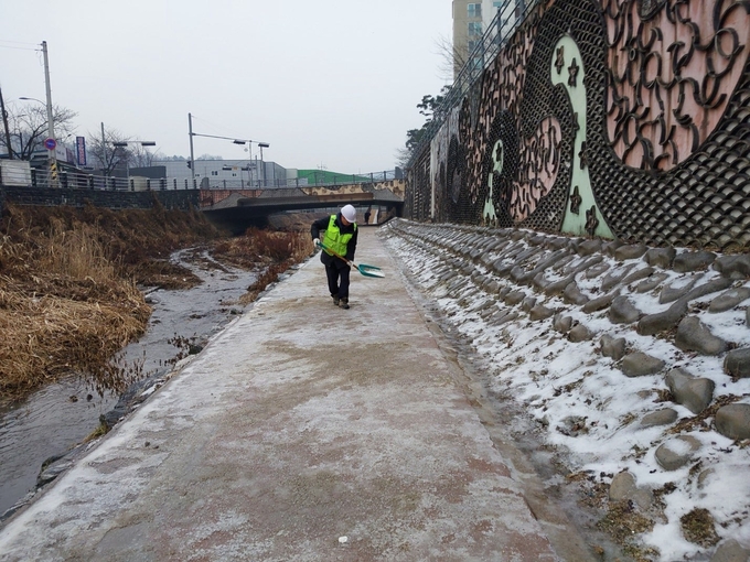 상하천 산책로 빙판길에 모래가 포설됐다. (사진=용인시 제공)