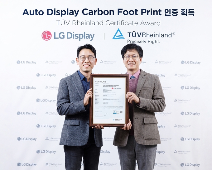  '제품 탄소발자국' 인증 수여식에서 기념촬영 중인 김종만 티유브이 라인란드(TUV Rheinland) 전기전자 사업부 이사(오른쪽)와 권극상 LG디스플레이 Auto 제품개발1담당(상무). (사진=LG디스플레이 제공)