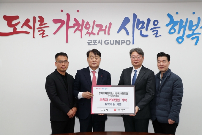 경기도자동차검사정비사업조합 안양지역협의회가 설맞이 이웃돕기 후원금을 기탁하고 있다. (사진=군포시 제공)
