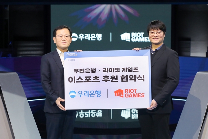 조병규 우리은행장(왼쪽)과 조혁진 라이엇 게임즈 코리아 대표가 e스포츠 후원 협약식에서 기념촬영을 하고 있다. (사진=우리은행 제공)