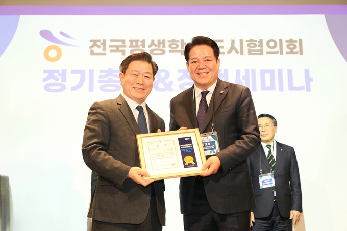 최대호 안양시장(오른쪽)이 박승원 전국 평생학습 도시협의회 회장으로부터 '대한민국 평생학습도시 좋은 정책상'을 수상하고 있다. (사진=안양시 제공)