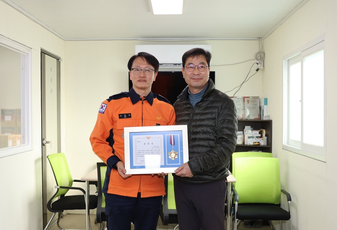 화성소방서가 하천 오염수 관련 복구활동 유공자인 윤형철 페인트월드 대표에게 소방서장 표창장을 전달하고 있다. (사진=화성소방서 제공) 