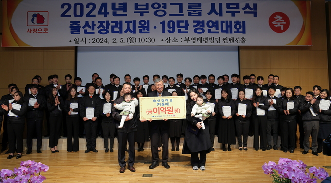 이중근 부영그룹 회장이 쌍둥이 딸을 둔 오현석 주임 가족에게 출산장려금을 지급하고 기념 촬영을 하고 있는 모습. (사진=부영그 제공)