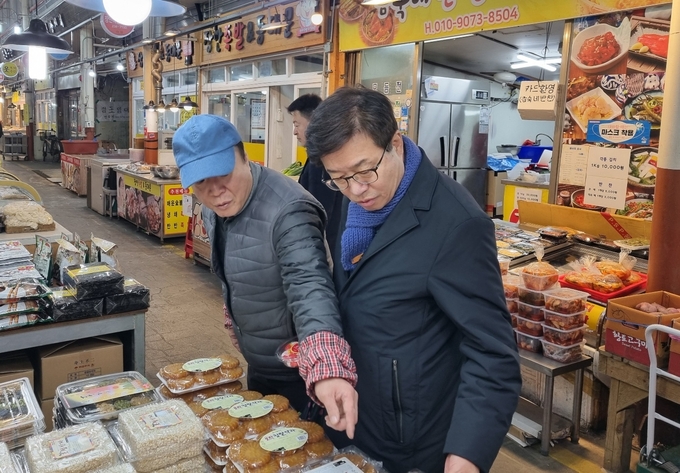 염태영 더불어민주당 수원무 국회의원 예비후보가 6일 권선종합시장을 찾아 한과 등을 구입하며 상인과 대화를 나누고 있다. (사진=염 예비후보 측 제공)