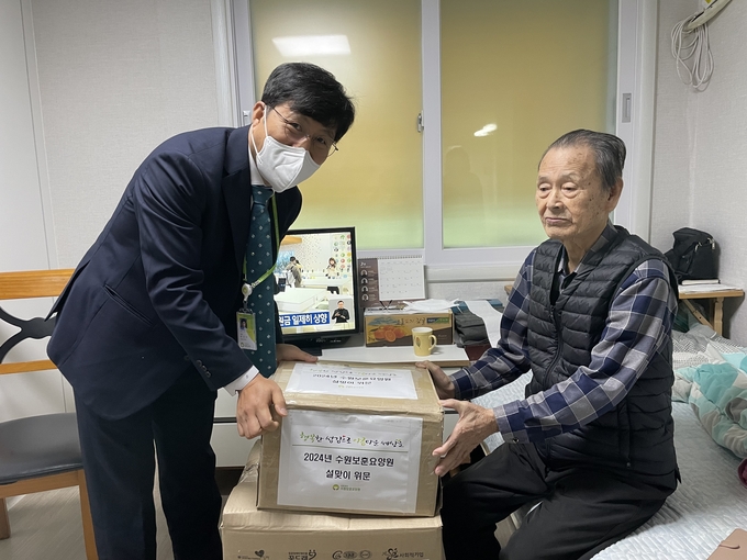 수원보훈요양원 박진기 회장이 국가유공자에게 설맞이 위문품을 전달하고 있다. (사진=수원보훈요양원 제공)
