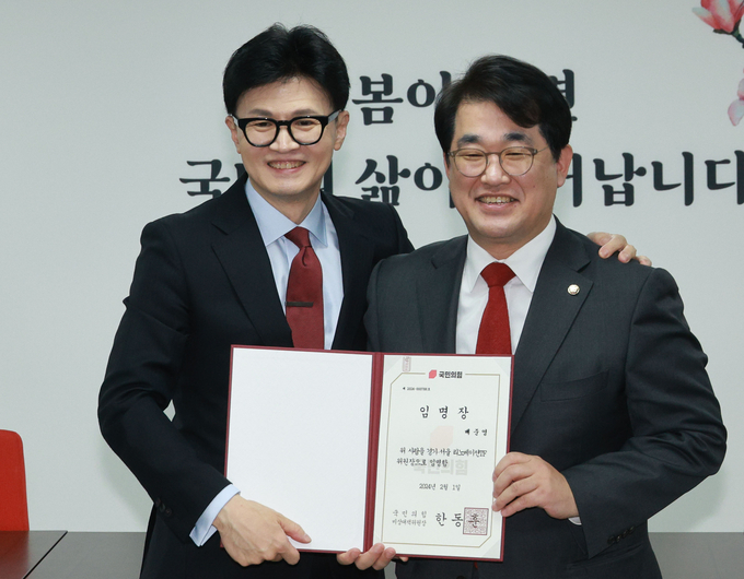 한동훈 국민의힘 비상대책위원장이 7일 여의도 국민의힘 중앙당사에서 열린 경기·서울 리노베이션TF 임명장 수여식에서 당 전략기획부총장인 배준영 의원에게 위원장 임명장을 수여한 뒤 기념촬영을 하고 있다. (사진=연합뉴스)