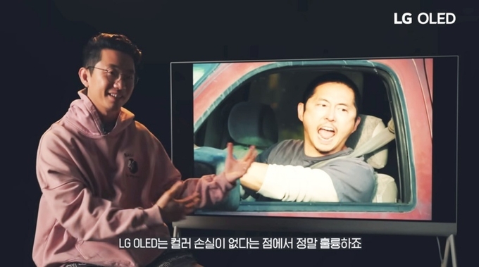 ‘성난 사람들’을 연출한 이성진 감독이 LG 올레드 TV 옆에서 포즈를 취하고 있는 모습. (사진=LG전자 제공)