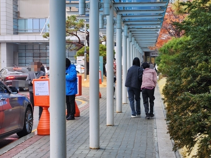 19일 아주대병원 한 보호자가 환자를 부축하고 병원을 나서고 있다. (사진=이보현 기자) 