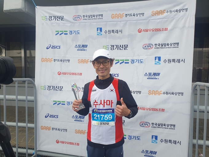 ‘2024 경기국제하프마라톤대회 마스터스 하프 남자 부문에서 우승한 김회묵 씨(수원·51)가 경기신문과의 인터뷰를 마치고 기념촬영을 하고 있다. (사진=마라톤 특별취재팀)