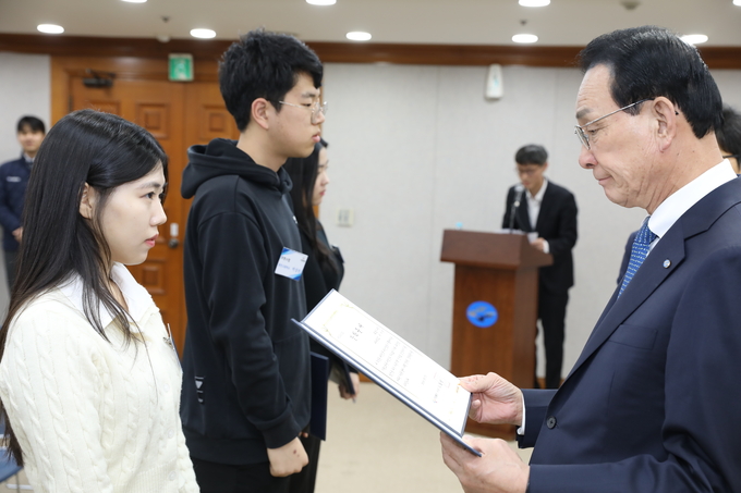 노동진 수협재단 이사장(왼쪽)이 선발된 어업인 자녀 장학생에게 장학증서를 수여하고 있다. (사진=수협중앙회 제공)