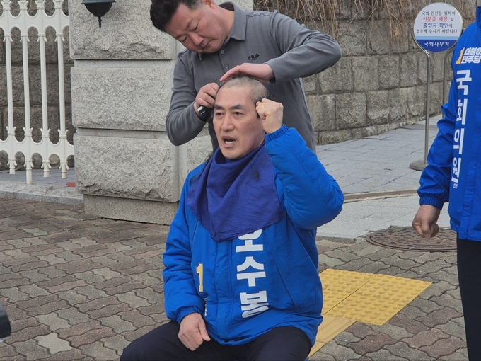 하남시장을 지낸 오수봉 더불어민주당 하남시 총선 예비후보가 6일 국회 출입문 앞에서 하남 갑·을 선거구의 전략공천에 반발하며 삭발식을 진행하고 있다. (사진=김한별 기자)