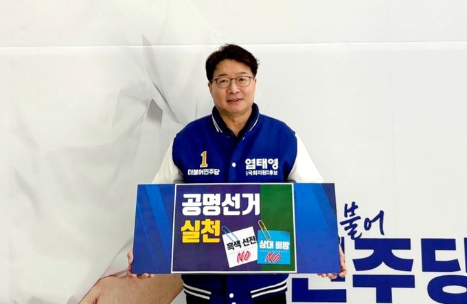 염태영 더불어민주당 수원무 국회의원 후보가 공명선거 실천 피켓을 들고 있다. (사진=염 후보 측 제공)