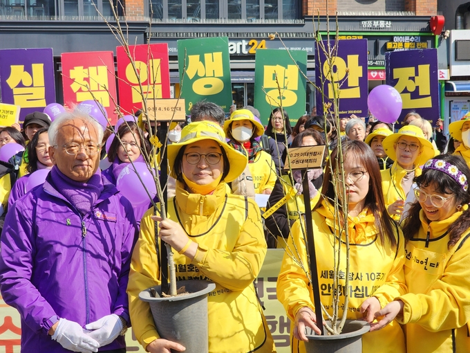 행진단이 생명안전부지에 심을 나무를 들고 사진을 찍고 있다. (사진=이보현 기자) 