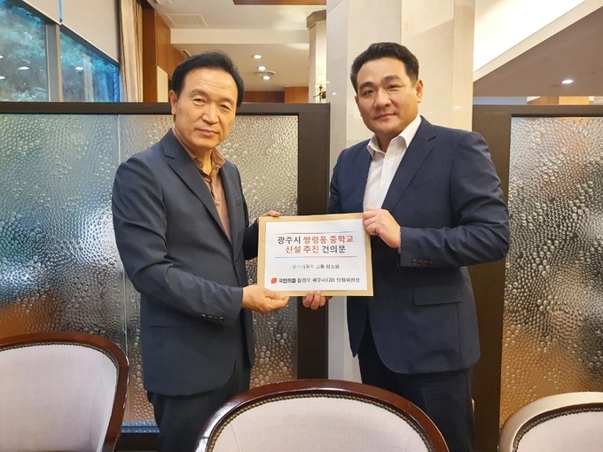 국힘 함경우 후보가 임태희 교육감에게 쌍령중학교 섭립 추진 건의문을 전달하고 있다.(사진=함후보 사무소)