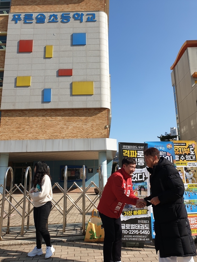 김포시 장기본동 라선거구 시의원 보궐선거에 나선 최성남 국민의힘 후보가 핵심 공약이 적힌 명함을 주민에게 건네고 있다. (사진=천용남 기자)