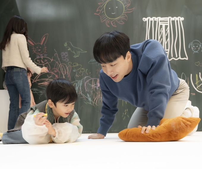 스타필드 고양 ‘예스 두들 앳 홈’ 행사에 참여한 가족이 바닥에 낙서를 하고 있는 모습. (사진=신세계프라퍼티 제공)