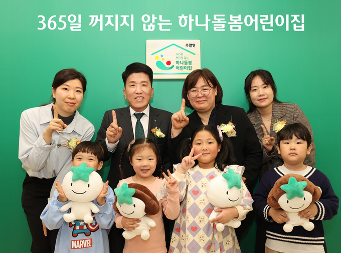 함영주 하나금융그룹 회장(둘째 줄 왼쪽 2번째)이 학부모 및 아이들, 어린이집 관계자들과 함께 '365일 꺼지지 않는 하나돌봄어린이집' 현판 앞에서 기념 촬영을 하고 있다. (사진=하나금융그룹 제공)