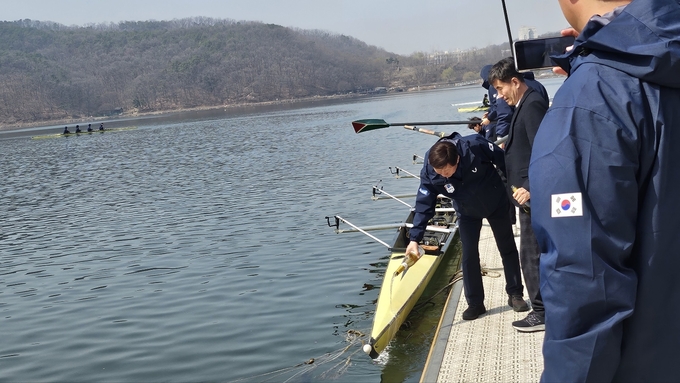 23일 용인조정경기장에서 열린 경기도조정협회 2024년 시조식에 참석한 관계자들이 보트에 술을 부으며 무사고를 기원하고 있다. (사진=유창현 기자)
