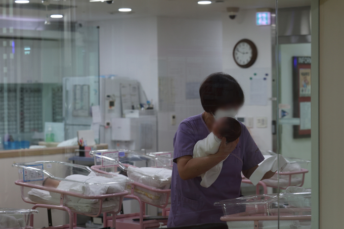서울 시내 한 산후조리원 신생아실에서 한 관계자가 신생아를 돌보고 있다. (사진=연합뉴스 제공)