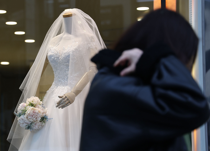 서울 마포구 아현동 웨딩거리에서 한 시민이 웨딩드레스 앞을 지나고 있다. (사진=연합뉴스 제공)<br>
