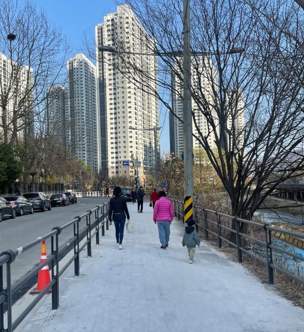 확장공사가 마무리된 안양 인덕원초교 앞 학의천변 보도에서 시민들이 산책하고 있다.(사진=안양시 제공)