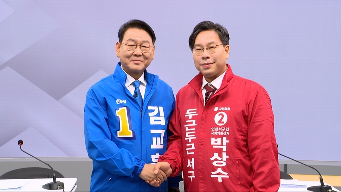 SK브로드밴드 인천방송 서구갑 후보자 토론회장에서 김교흥 더불어민주당 후보와 박상수 국민의힘 후보가 악수하며 기념촬영하고 있다. ( 사진 = SK브로드밴드 인천방송 제공 )