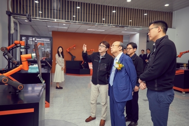 한화그룹 김승연 회장이 한화로보틱스 협동로봇의 설명을 듣고 있다. (사진=한화그룹 제공)