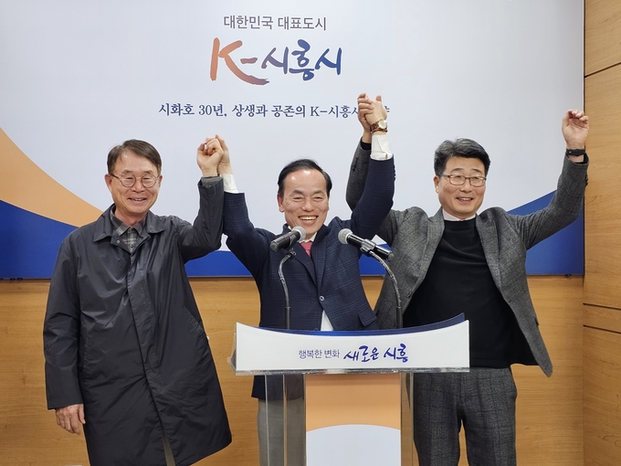 전 시흥시청 김기태 부시장과 김윤식 후보, 이충목 전 국장이 화이팅을 외치고 있다.(사진 왼쪽부터). (사진=이충목 전국장 제공)