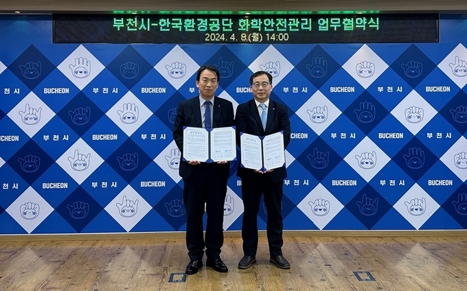 김우용 부천시 도시주택환경국장(왼쪽)과 유영권 한국환경공단 환경안전지원단장(오른쪽)이 협약서를 들고 기념촬영하고 있다. (사진=부천시 제공)