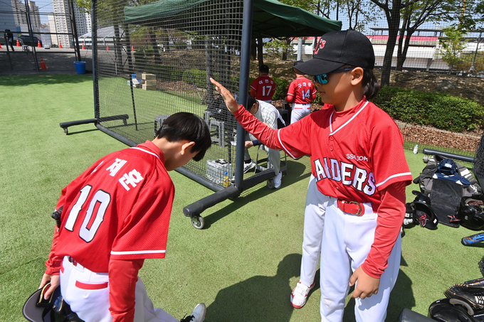 13일 오전 2024 수원배 전국유소년야구대회 티볼부 경기에서 공수교대 중 팀원과 하이파이브를 하고 있다.