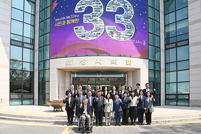 화성시의회 의원들이 개원 33주년 현수막 앞에서 기념촬영을 하고 있다. (사진=화성시의회 제공)