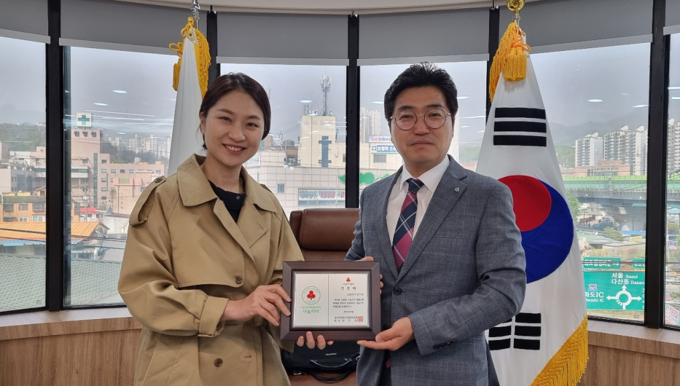 남양주 화도새마을금고 신기문 이사장(오른쪽)이 신영미 동부희망케어센터장으로부터 ‘나눔 리더’ 인증패를 받고 있다. (사진=남양주시 제공)