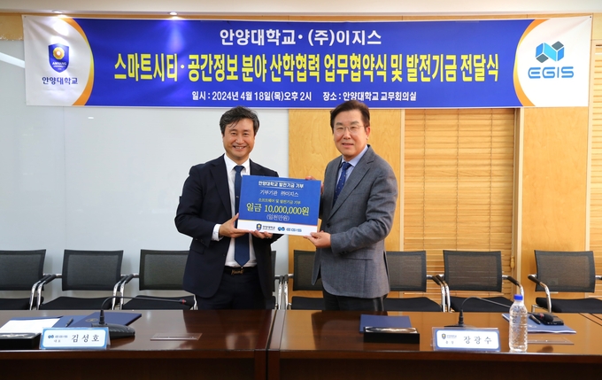 김성호 이지스 대표(왼쪽)가 18일 안양대 일우중앙도서관에서 열린 업무협약식에서 장광수 안양대 총장에게 발전기금 1000만원을 기탁하고있다.(사진=안양대 제공)