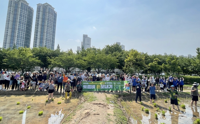 상동호수공원 ‘토종벼 손모내기’ 프로그램에 참여한 시민들이 활짝 웃으며 기념촬영을 하고 있다. (사진=부천시 제공)
