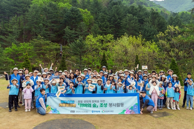 ‘위비의 숲 조성’ 봉사활동에 참여한 WOORI 가족 봉사단이 기념촬영을 하고 있다. (사진=우리은행 제공)