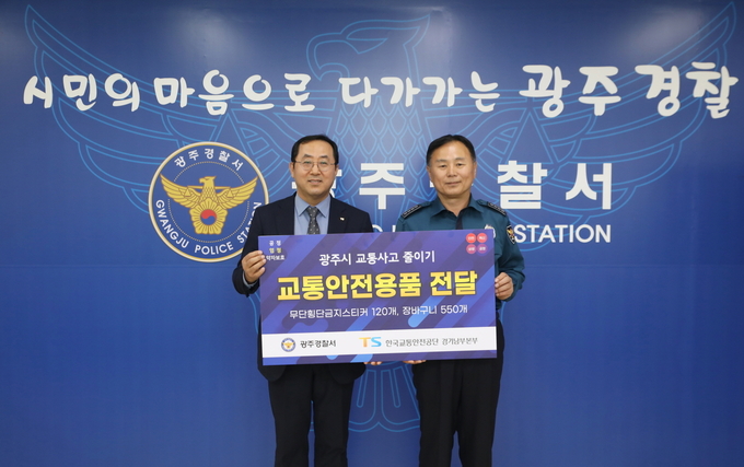 23일 광주경찰서에서 조정권 본부장(왼쪽)이 유제열 서장에게 교통안전용품을 전달하고 있다. (사진=광주서 제공) 