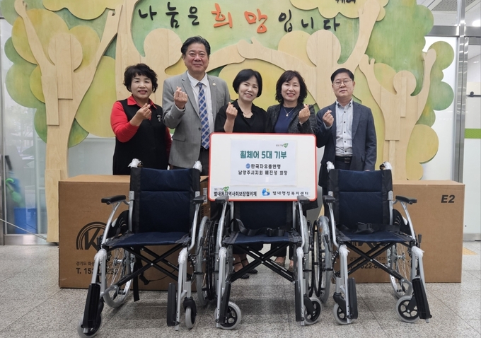배진성 한국자유총연맹 남양주시지회장이 23일 지역복지사업을 위해 휠체어 3대를 기부하고 관계자들과 기념촬영을 하고 있다. (사진=남양주시 제공)