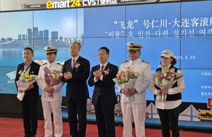 인천~대련 한·중 국제카페리 재개한 25일 인천항만공사는 첫 여객과 선장에게 꽃다발을 전달하고 기념촬영을 하고 있다. ( 사진 = 인천항만공사 제공 )