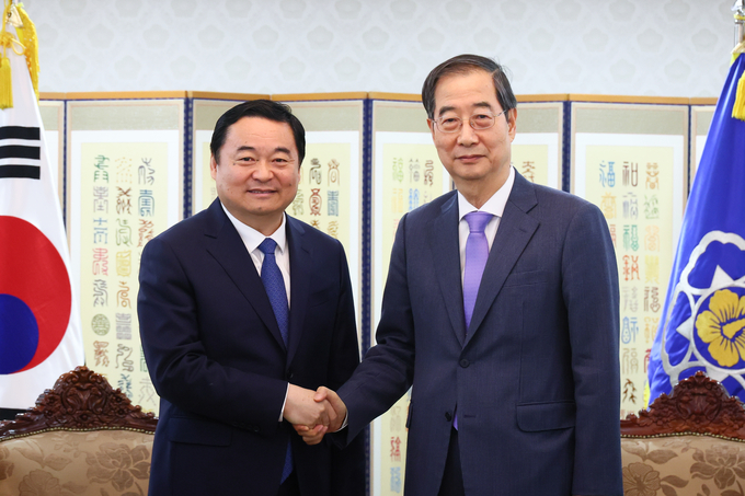 25일 서울 종로구 정부서울청사에서 한덕수 국무총리(오른쪽)와 하오펑 중국 랴오닝성 당서기가 악수하고 있다. (사진=국무총리실 제공)