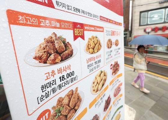 서울 시내 한 굽네치킨 매장 앞에 인상 이전 가격 안내판이 놓여 있다. (사진=연합뉴스 제공)