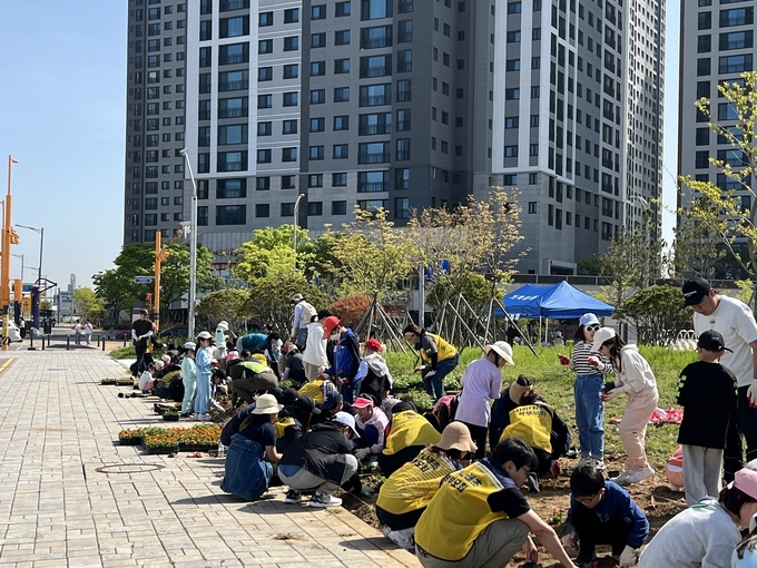 시흥시 거북섬동 행정복지센터는 지난 27일 시화나래초중학교 옆 완충녹지에서 지역주민, 학생들과 함께하는 꽃 심기 행사를 개최했다.<br>
(사진=시흥시 제공)