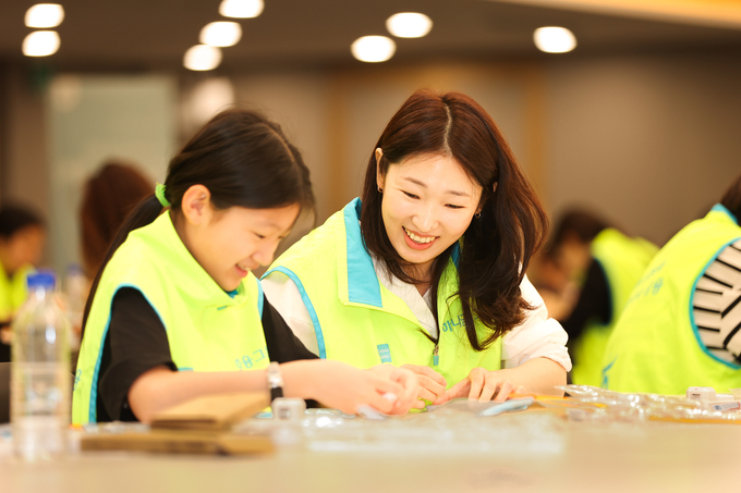 봉사활동에 참여한 하나금융그룹 직원과 가족이 시각장애인용 점자 교구를 제작하고 있다. (사진=하나금융그룹 제공)
