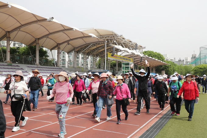 '한마음 치매 극복 걷기' 행사에 참석한 시민들이 시민체육광장을 걷고 있다. (사진=군포시 제공)