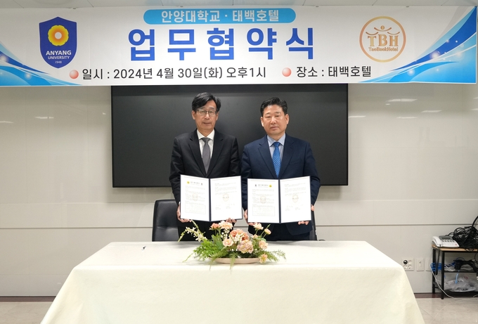 장용철 안양대 부총장(왼쪽)과 이용철 태백호텔 총지배인이 30일 업무협약을 맺은 뒤 협약서를 들어보이고 있다. (사진=안양대 제공)